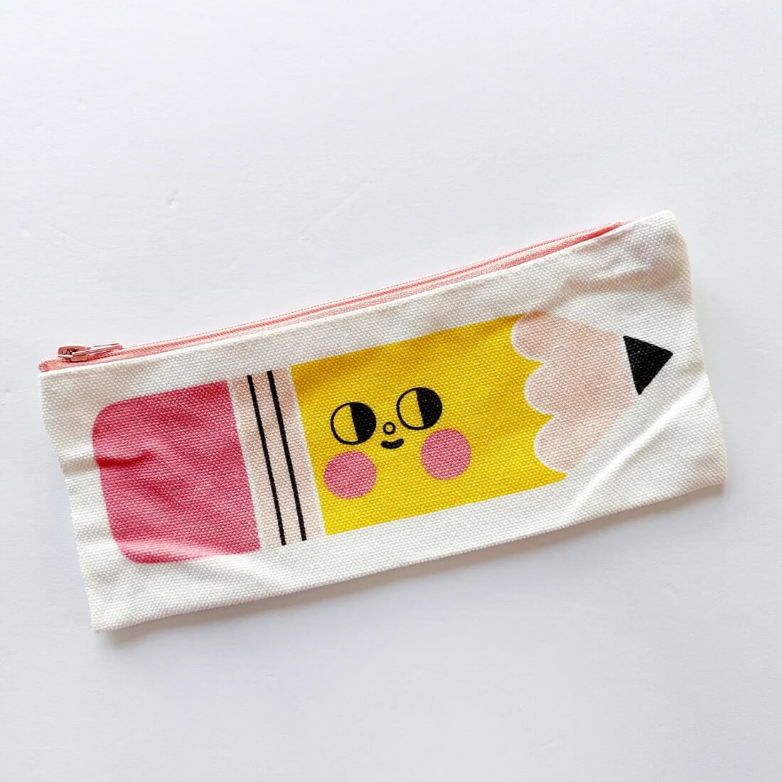 A pencil case with a cute pencil character on the side.